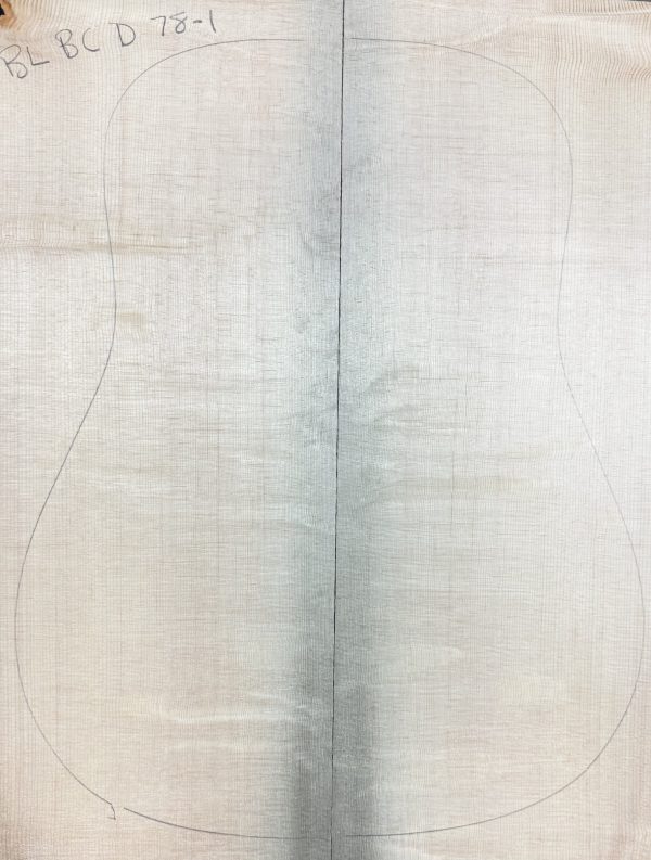 Light-colored Sitka Spruce wood blanks, joined vertically, with a pencil outline of a guitar body drawn over them.