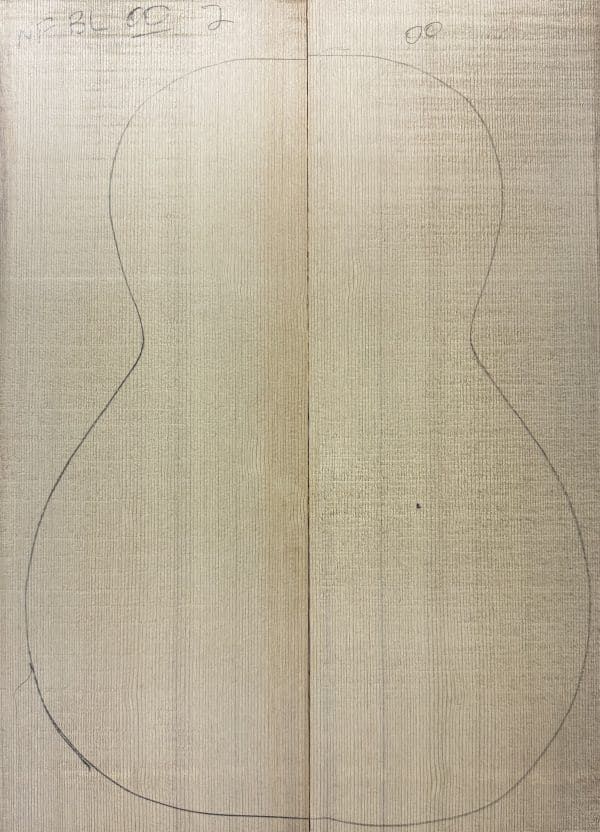 Book-matched light wood panels with a faint pencil outline of a guitar body, perfect for crafting One-of-a-Kind Guitar Tops.