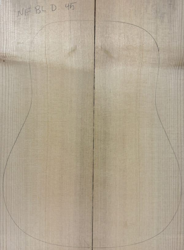 Pale, joined wooden plank with vertical grain and a penciled guitar body outline, a blank for Blue Non-Figured Guitar Tops.