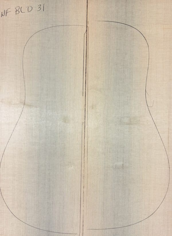 Two matched light spruce wood pieces with a pencil outline of a guitar body, representing One-of-a-Kind Guitar Tops.