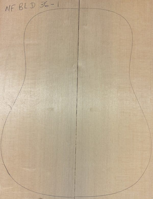 Acoustic guitar body outline drawn on quartersawn wood pieces, showcasing raw material for Blue Non-Figured Guitar Tops.