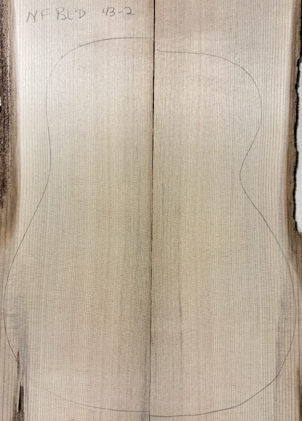Two light-colored, quarter-sawn Sitka Spruce planks prepared to become One-of-a-Kind Guitar Tops, with an acoustic guitar outline.