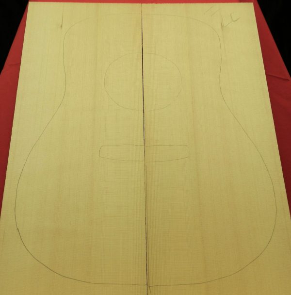 Two bookmatched pieces of light-colored Sitka Spruce Dread wood with a pencil outline of an acoustic guitar body.