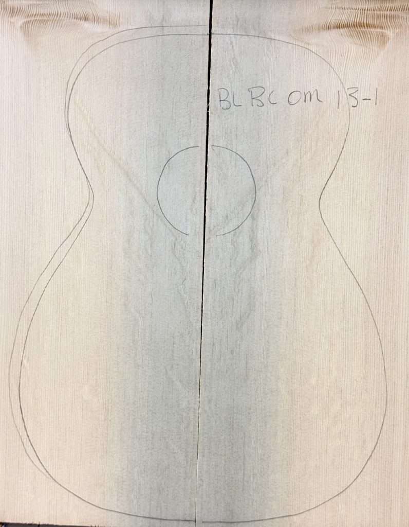 Pencil-outlined acoustic guitar body on joined light wood pieces (BLBCOM 13-1), showcasing fine vertical grain, ideal for Blue Bearclaw Guitar Tops.