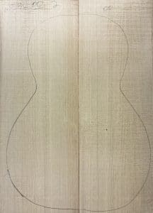 Book-matched light wood panels with a faint pencil outline of a guitar body, perfect for crafting One-of-a-Kind Guitar Tops.