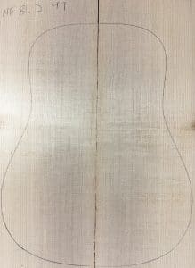 Mirror-matched, vertically-grained Blue Non-Figured Guitar Tops made from light-colored wood, with a guitar body outline drawn on them and the label NF BL D 47.