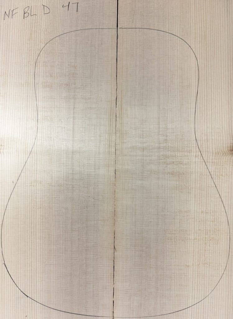 Mirror-matched, vertically-grained Blue Non-Figured Guitar Tops made from light-colored wood, with a guitar body outline drawn on them and the label NF BL D 47.